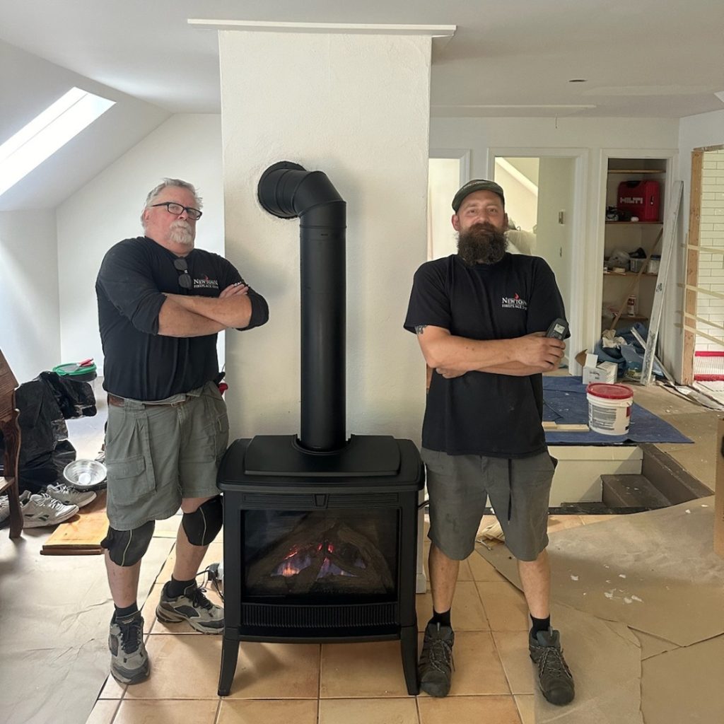 Newtown Fireplace Shop employees next to a stove they installed