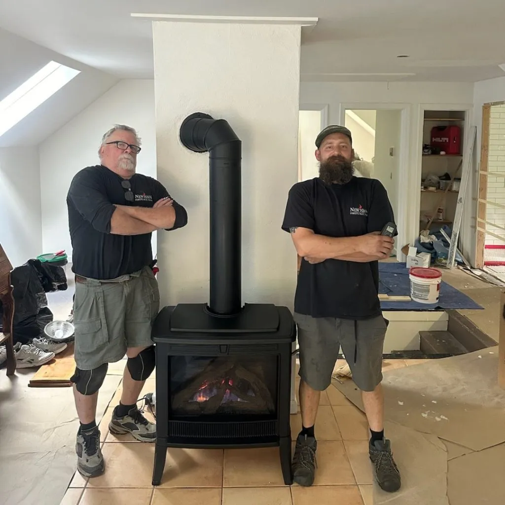 Newtown Fireplace Shop employees next to a stove they installed